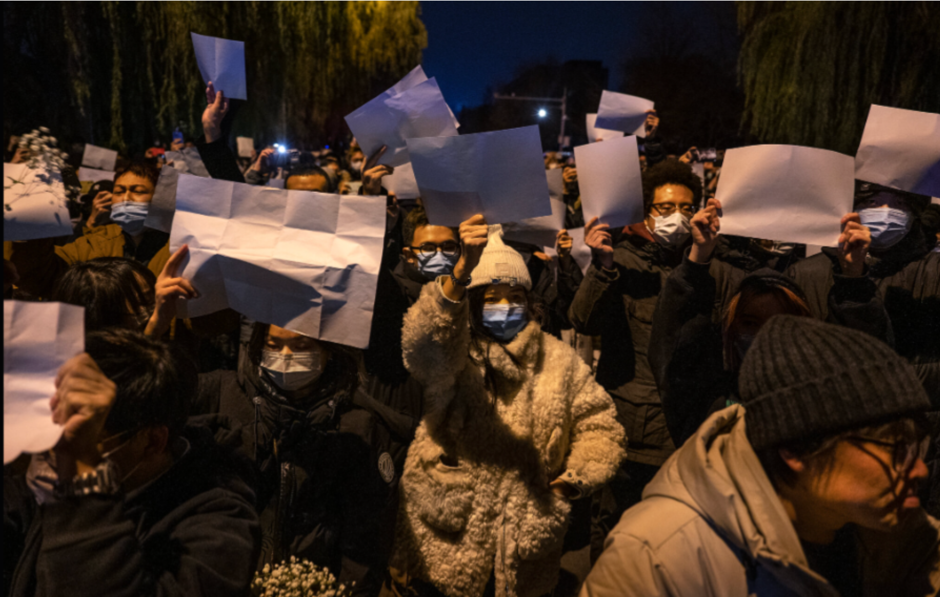 Protesters in China holding blank sheets of paper, symbolizing public frustration and loss of confidence.