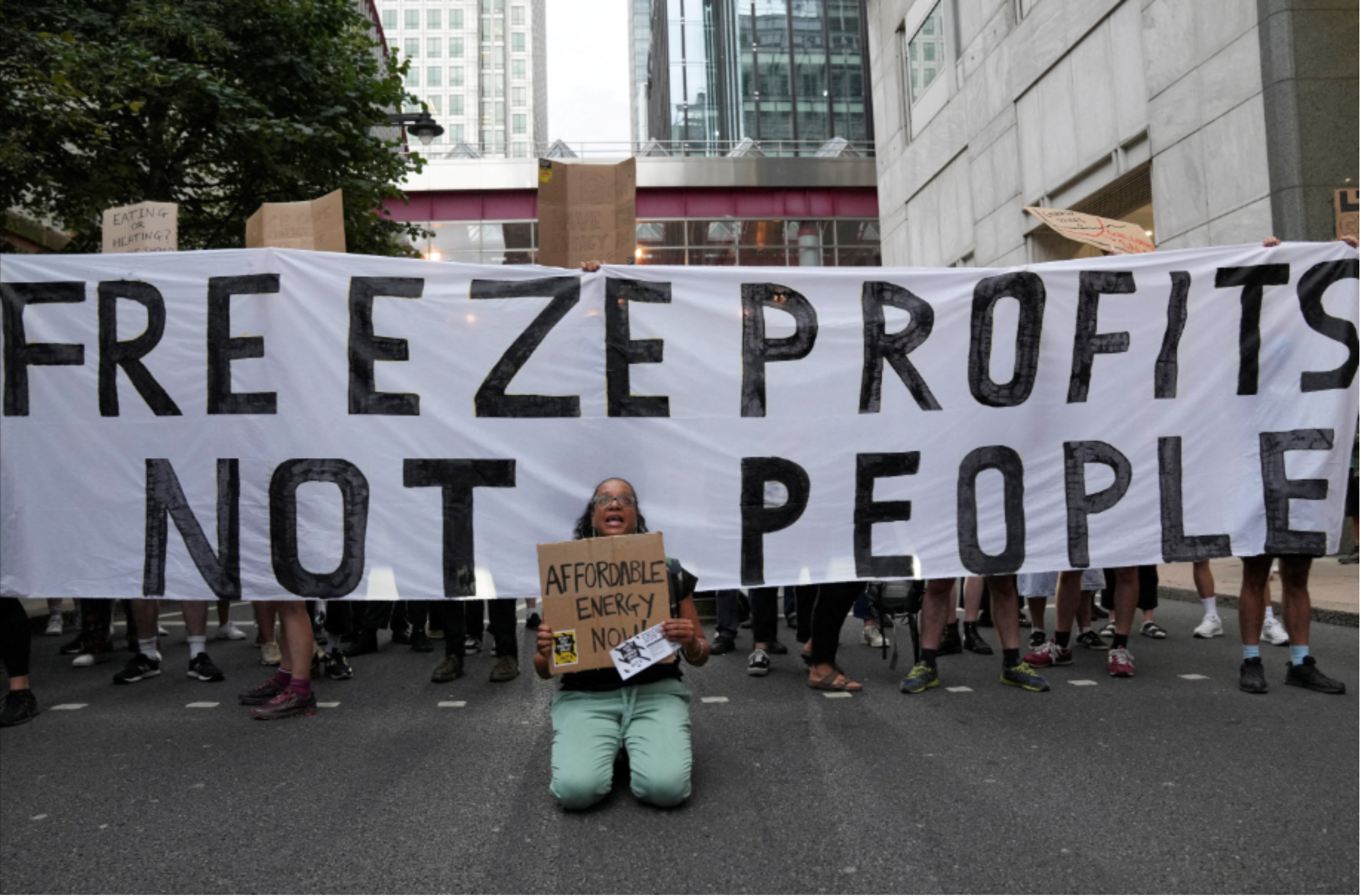 Protesters holding a banner saying free energy profits, not people, during a demonstration over energy costs.